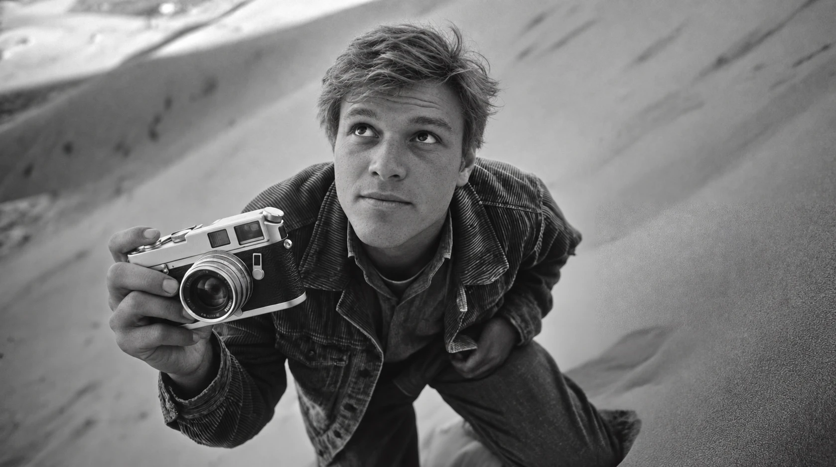 Luis Rau holding a camera on a sand dune